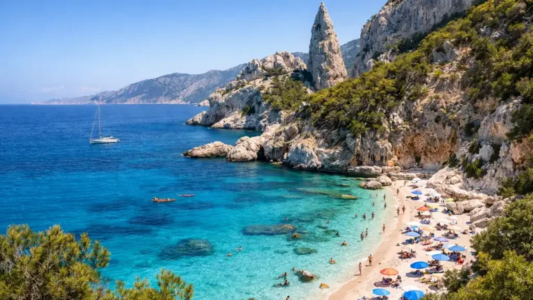 Vue réaliste d’une crique de Sardaigne avec eau turquoise, plage claire, falaises calcaires et paysage méditerranéen sauvage