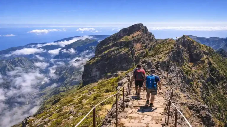 Randonnée PR1 à Madère sur les crêtes entre Pico do Areeiro et Pico Ruivo, sentier rocheux avec vue sur les nuages et l’océan Atlantique.