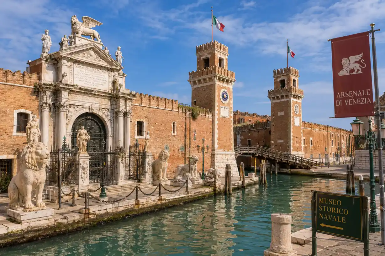 Entrée historique de l’Arsenal de Venise avec lions, canal et bâtiments navals.