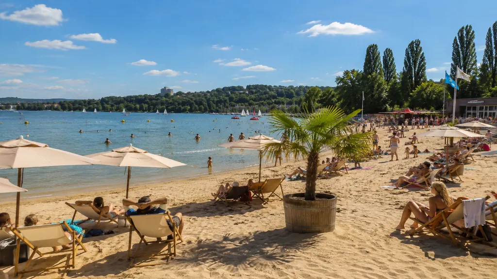 Plage urbaine de Dijon au bord du lac Kir avec sable, transats, baignade surveillée et ambiance estivale.