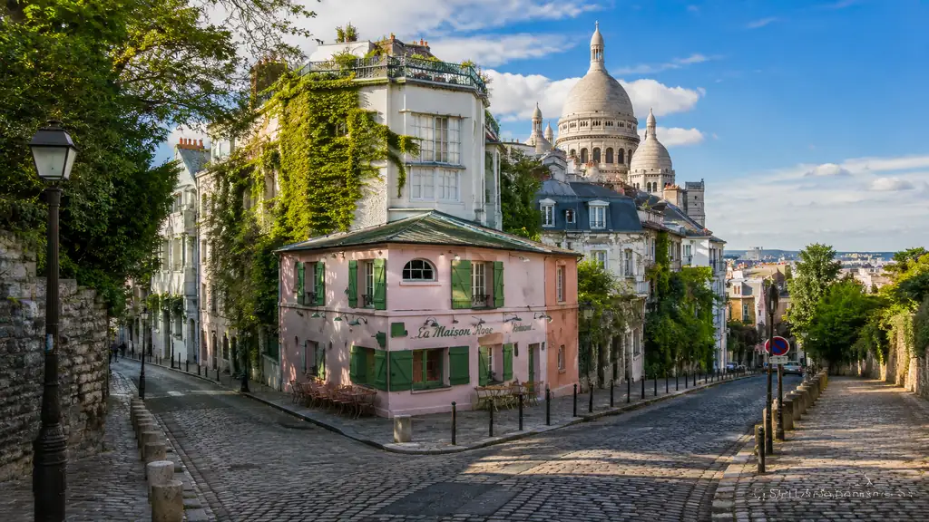 Itinéraire à pied dans Montmartre avec rue pavée, Maison Rose et Sacré-Cœur en arrière-plan.