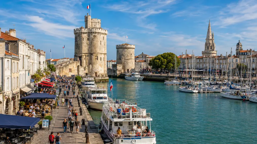 Vue du Vieux-Port de La Rochelle avec les tours médiévales, les bateaux et les quais animés.