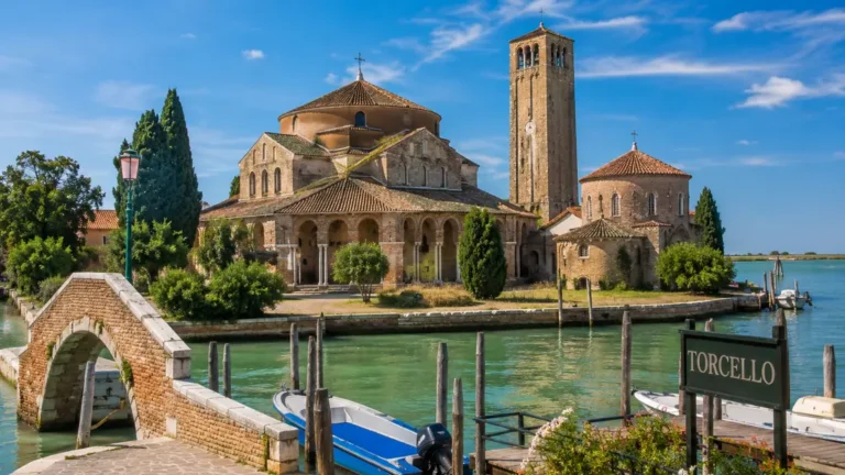 Île de Torcello dans la lagune de Venise avec basilique byzantine, campanile, canal et barques au bord de l’eau