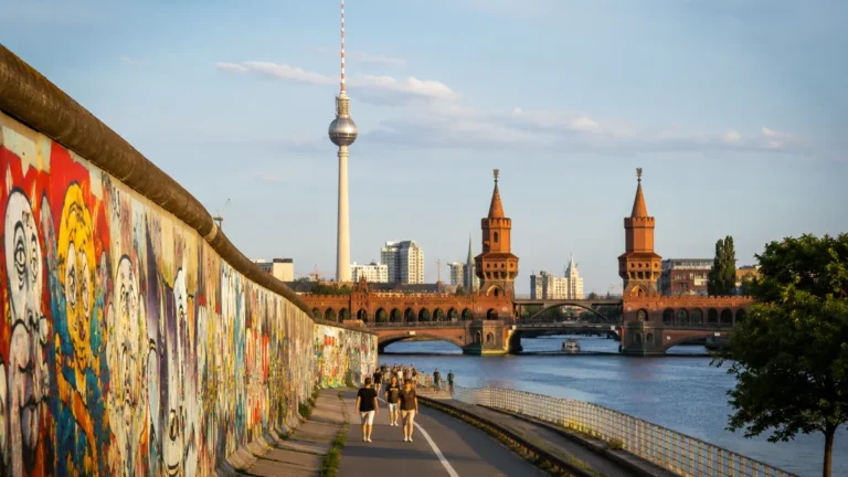 Vue réaliste de Berlin avec l’East Side Gallery, la Spree et la tour Fernsehturm au coucher du soleil.