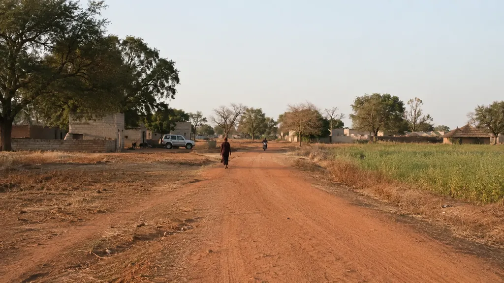 Village rural de Falifa au Sénégal avec piste en latérite, champs et habitations traditionnelles près de Kaolack