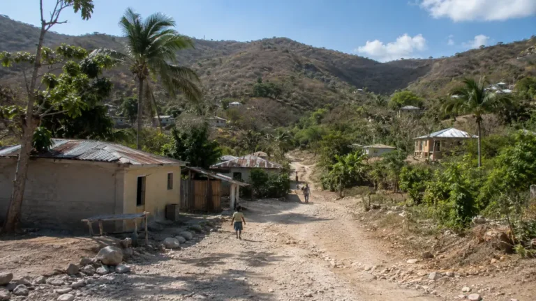 Village rural de Ganere en Haïti avec piste en terre, maisons modestes et collines sèches