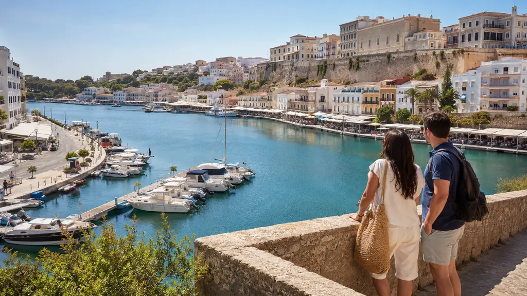 Vue panoramique sur le port de Mahón à Minorque avec bateaux, quais animés et centre historique dominant la baie