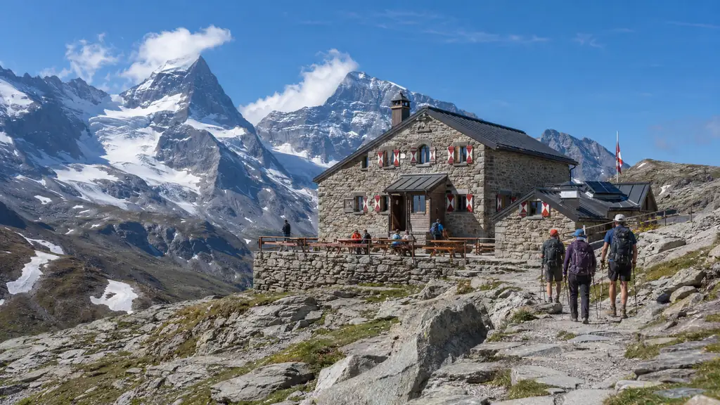 Randonneurs arrivant au refuge du Col de la Vanoise avec sommets enneigés, glaciers et paysage alpin de Savoie