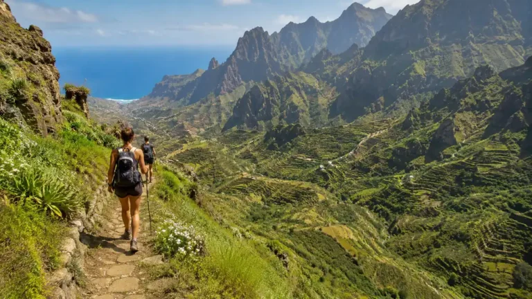 Randonneurs sur les sentiers montagneux de Santo Antão au Cap-Vert avec vallées verdoyantes et océan en arrière-plan