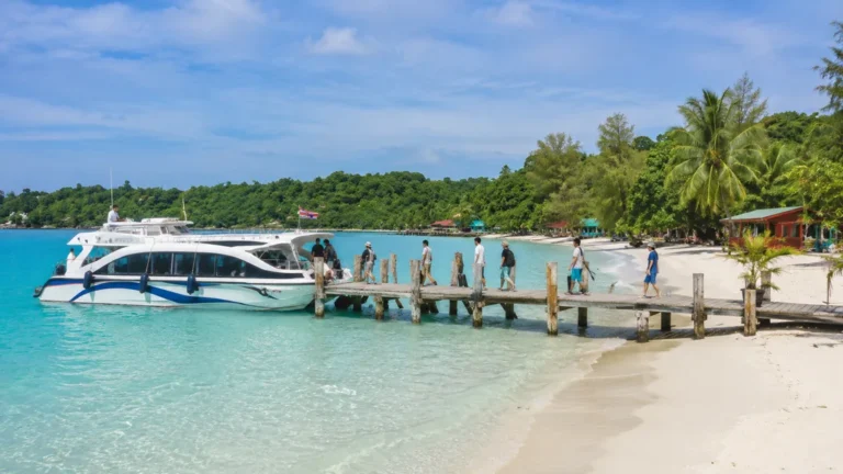 Voyageurs débarquant d’un ferry à Koh Rong depuis Sihanoukville avec eau turquoise, plage de sable blanc et végétation tropicale.